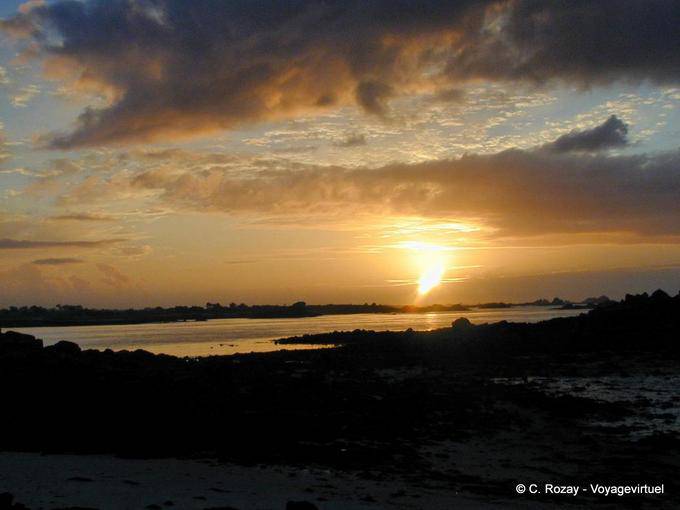 Ou o pôr do sol sobre a península e enseada Perharidy Laber, Roscoff, Bretanha - França