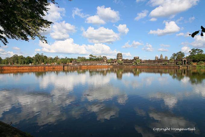 Nuvens e céu azul que refletem na grande fosso de Angkor Wat, Angkor, Camboja