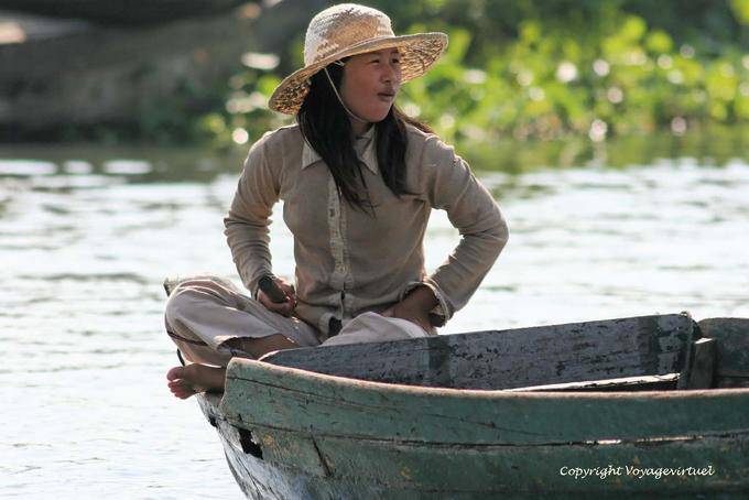 Mulher em posição de lótus em um barco, lago Tonle Sap - Camboja