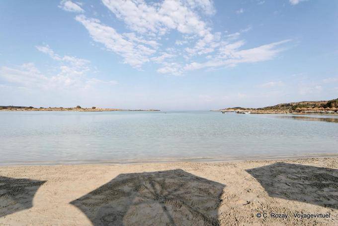 Guarda-chuvas sombras sobre a areia, Elafonissi - Creta, Grécia