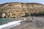 A praia em arco e do local protegido das cavernas túmulo de Matala, Creta.
