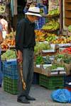 Cana-de-cretense em frente a uma barraca de frutas e vegetais, Rethymnon, Creta.