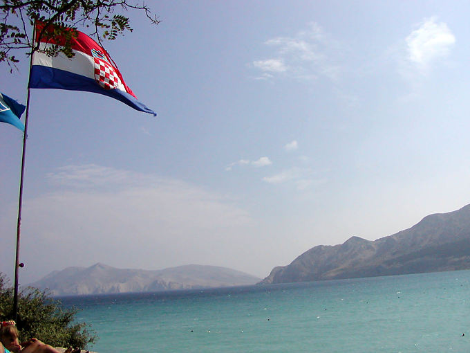 Flutuante bandeira croata na frente do Adriático, Krk, Croacia