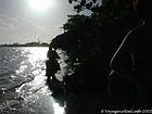Contra a luz, motocicleta passando sobre as ondas, Boca Chica, Rep. Dominicana.