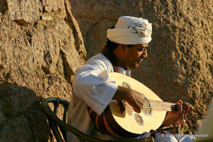 Músico que joga o 3ood, alaúde oriental antes do Old Cataract Assuão - Egipto