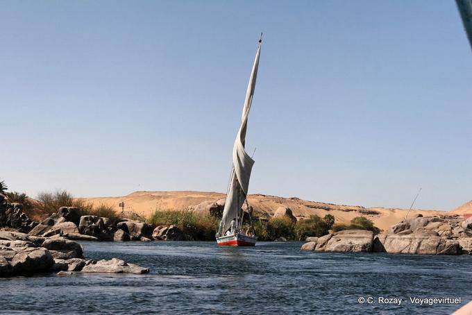 Mude para uma marcha lenta felucca entre as pedras salientes, Assuão - Egipto
