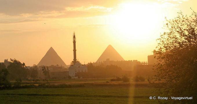 O minarete entre as pirâmides ao pôr do sol, Cairo - Egipto