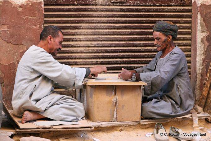 Jogadores de dominó no cartão em uma rua, Luxor - Egipto