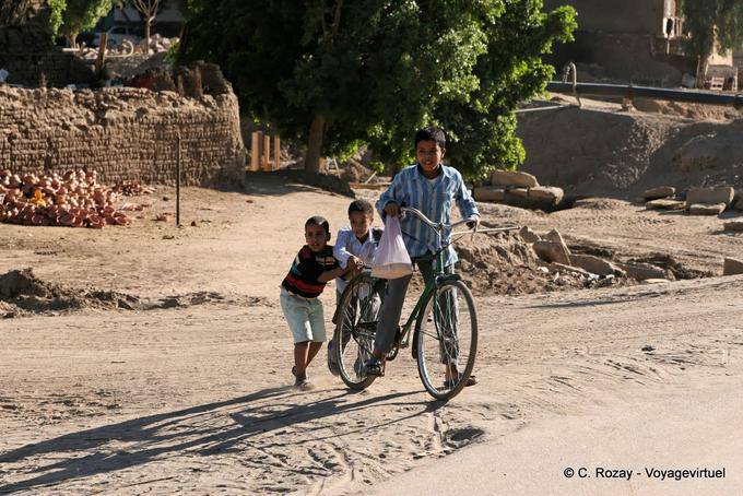 Três crianças com uma bicicleta, Luxor - Egipto