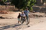 Três crianças com uma bicicleta, Luxor, Egipto.