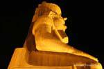 Ao pé de Ramsés II sessão colosso, visão noturna, Templo de Luxor, Egipto.