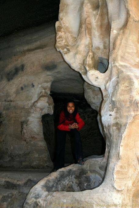 Criança de sorriso em uma sala de jantar caverna, equipado com uma piscina, Little Petra - Jordania