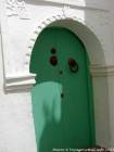A porta verde com uma mão de Fatma, Asilah, Marrocos.