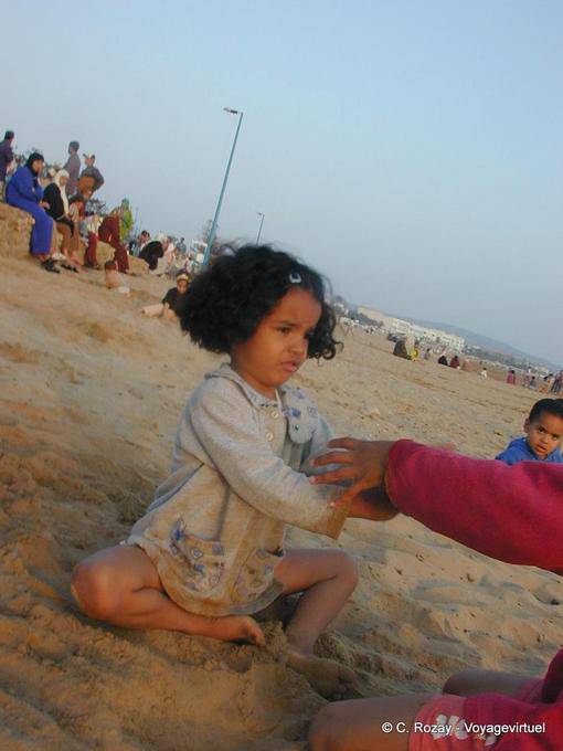 Uma menina que joga na praia Tagharte, Essaouira - Marrocos