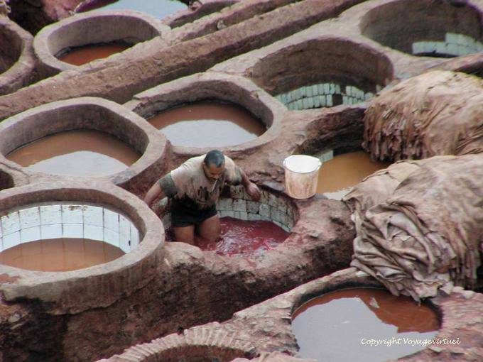 O trabalho duro do tintureiro no tanque com paredes de cerâmica, Fes - Marrocos