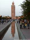 Reflexão do minarete iluminado em um lago no jardim da Koutoubia, Marrakech, Marrocos.