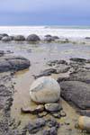 Na praia deserta, Pedregulhos Moeraki Scenic Reserve, Otago, Nova Zelândia.