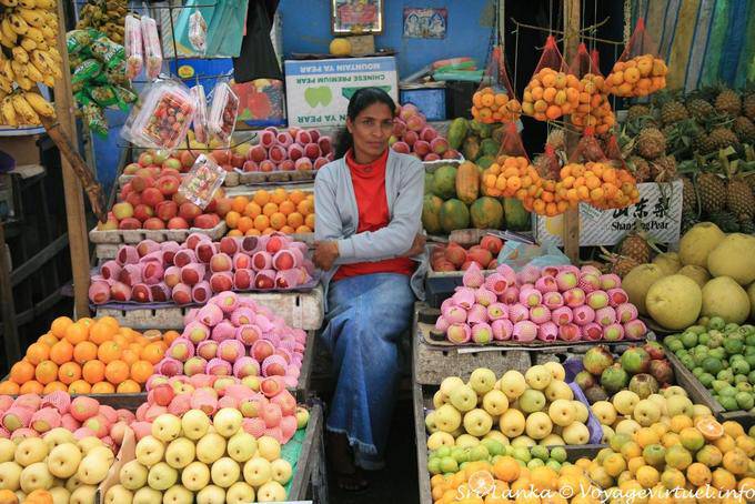 Vendedora entre maçãs e laranjas no mercado, Nuwara Eliya - Ceilão Sri Lanca