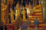 Buddhas em pé ao pé da Phra Buddha Chinnarat, Wat Phra Si Rattana Mahatha, Phitsanulok, Tailândia.