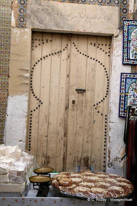 Porta de madeira velha atrás uma tenda guloseimas, Sousse medina - Tunísia