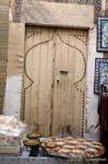 Porta de madeira velha atrás uma tenda guloseimas, Sousse medina, Tunísia.